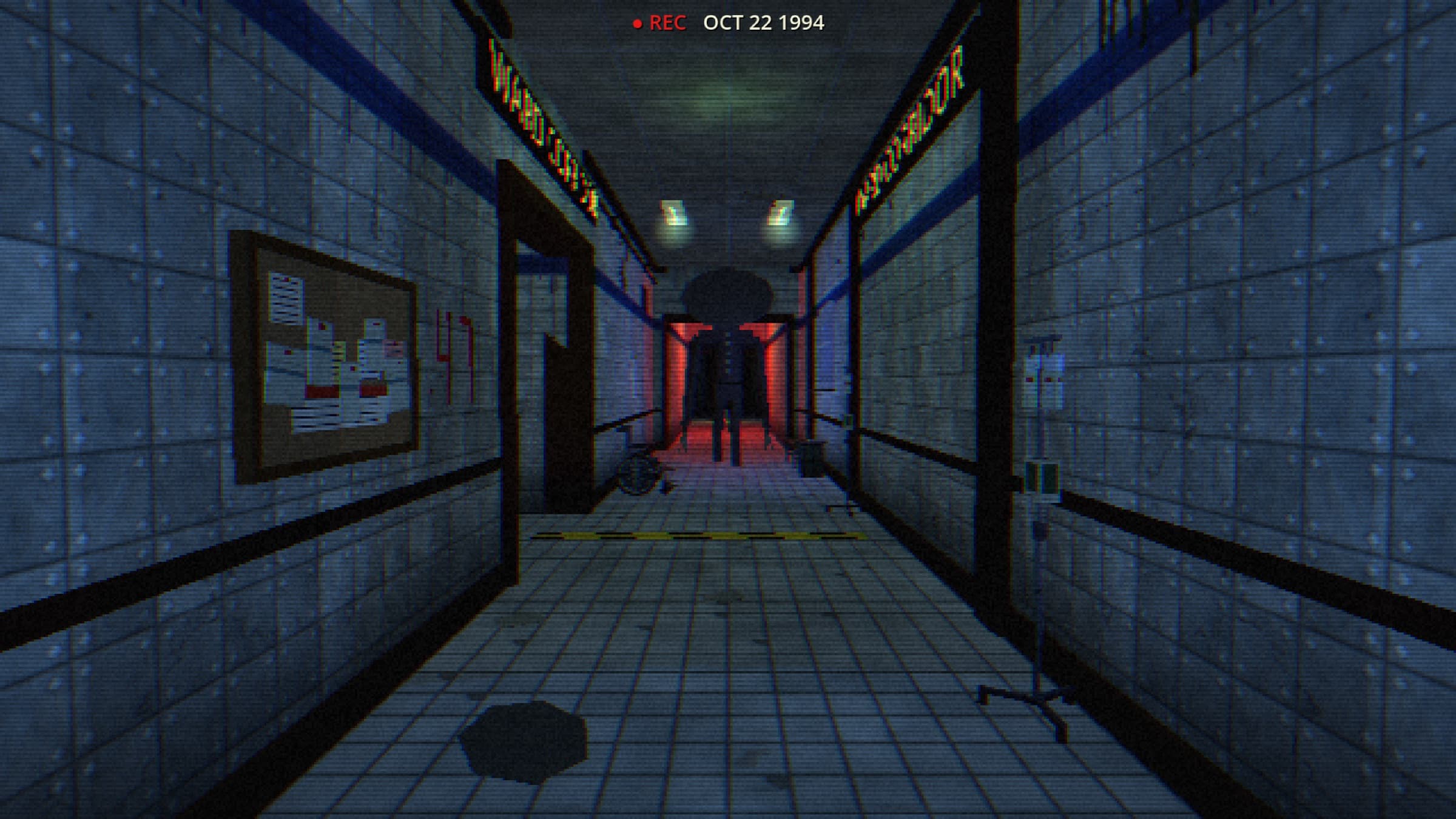 A tiled hospital corridor on a camcorder recording, a tall silhouette in a red-lit doorway at the far end.